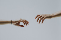 zwei Hände versuchen einander zu greifen